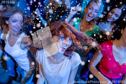Image of smiling friends dancing in club