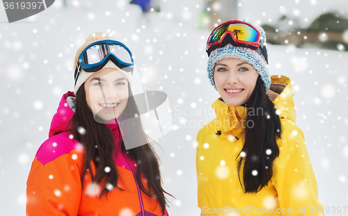 Image of happy girl friends in ski goggles outdoors