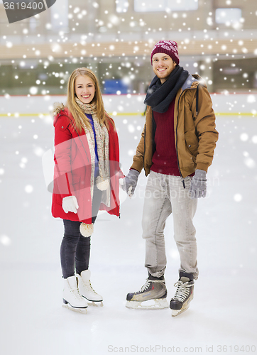 Image of happy couple holding hands on skating rink