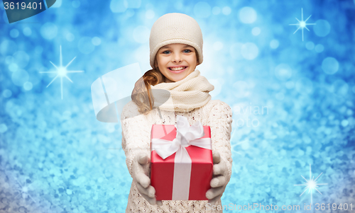 Image of girl in hat, muffler and gloves with gift box