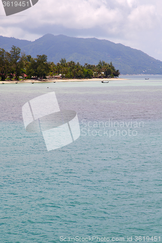 Image of  phangan  bay  coastline of a green lagoon  boat and tree 