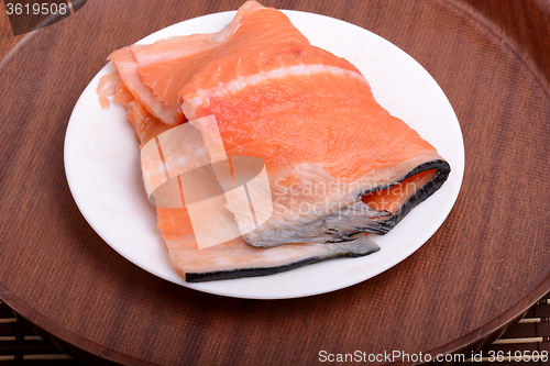 Image of Raw salmon fish steaks with fresh herbs on white plate