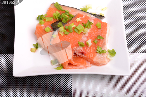 Image of Salted salmon fillet with parsley leaf on the white bowl