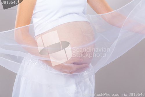 Image of Pregnant woman in white chiffon shawl