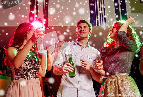 Image of smiling friends with wine glasses and beer in club