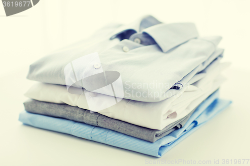 Image of close up of ironed and folded shirts on table