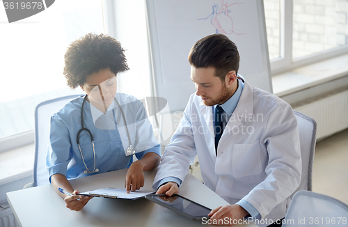Image of doctors with tablet pc and clipboard at hospital