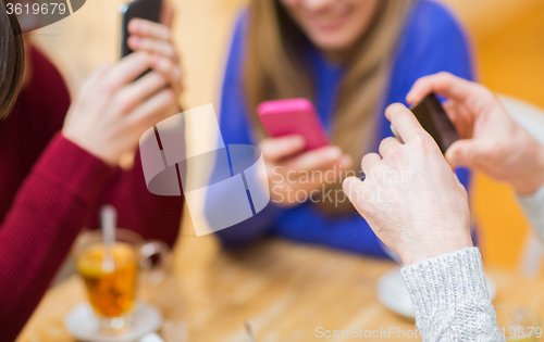 Image of group of friends with smartphones meeting at cafe