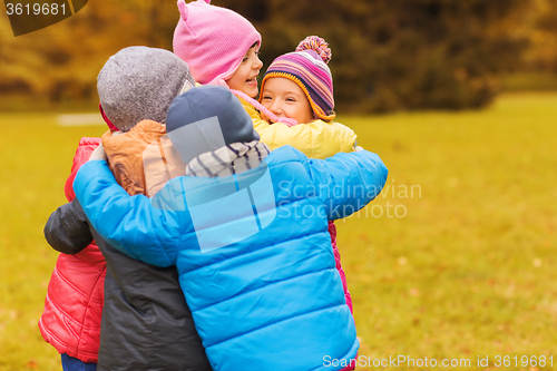 Image of group of happy children hugging in autumn park