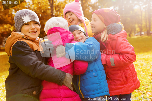 Image of group of happy children hugging in autumn park