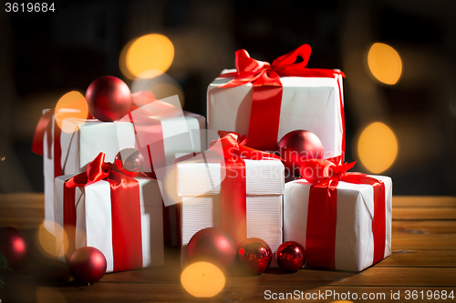 Image of gift boxes and red christmas balls on wooden floor