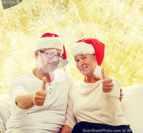 Image of happy senior couple in santa helper hats