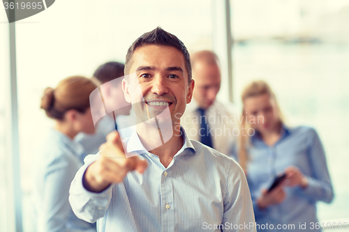 Image of group of smiling businesspeople meeting in office