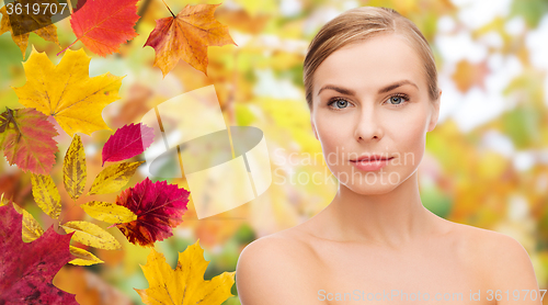 Image of beautiful young woman face over autumn leaves