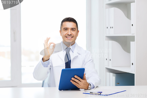 Image of smiling doctor with tablet pc showing ok hand sign