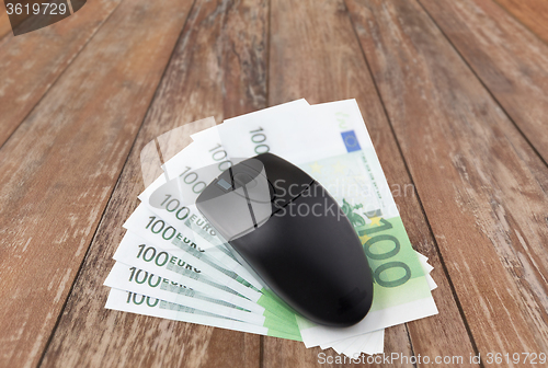 Image of close up of computer mouse and euro cash money