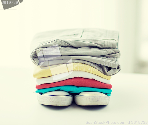 Image of close up of folded shirts and boots on table