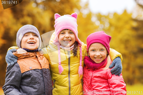 Image of group of happy children hugging in autumn park