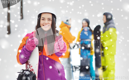 Image of happy friends in helmets with snowboards