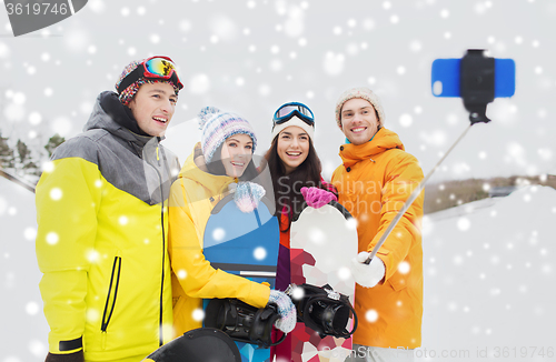 Image of happy friends with snowboards and smartphone