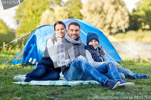 Image of happy family with tent at camp site