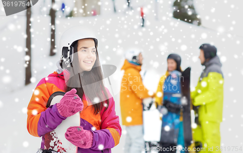 Image of happy friends in helmets with snowboards