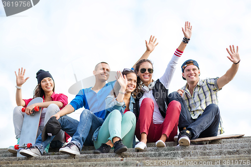 Image of group of teenagers waving hands