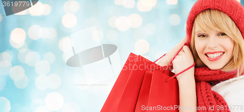 Image of woman in red hat and scarf with shopping bags