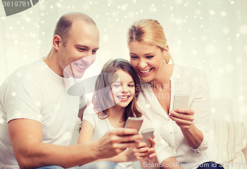 Image of happy family with smartphones at home