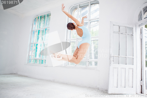 Image of young modern ballet dancer jumping on white background