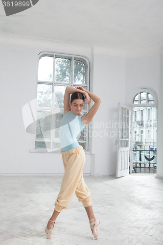 Image of young modern ballet dancer posing on white background