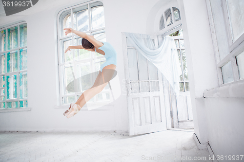 Image of young modern ballet dancer jumping on white background