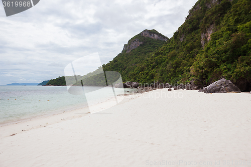 Image of Beach on tropical island. Clear blue water, sand, clouds. 