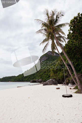 Image of Beach on tropical island. Clear blue water, sand, clouds. 