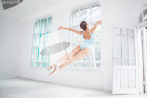 Image of young modern ballet dancer jumping on white background