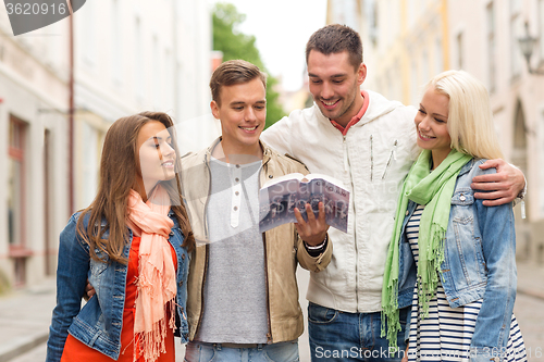 Image of group of friends with city guide exploring town