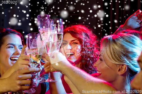 Image of smiling friends with glasses of champagne in club