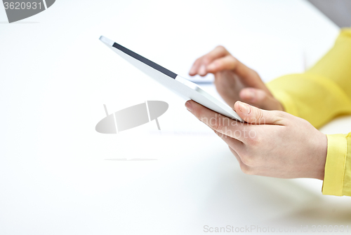 Image of close up of female hands with tablet pc at table