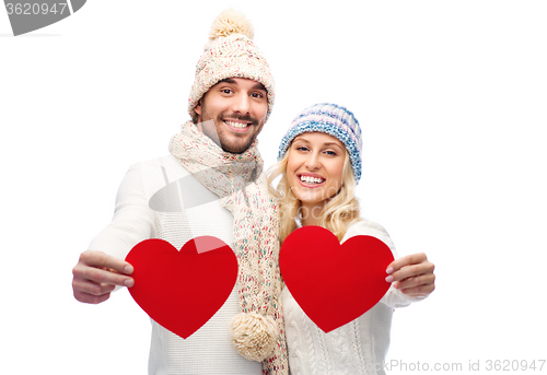 Image of smiling couple in winter clothes with red hearts