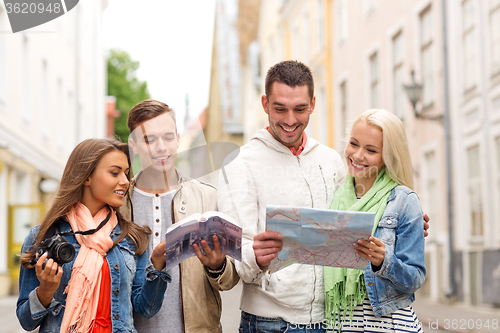 Image of group of friends with city guide, map and camera