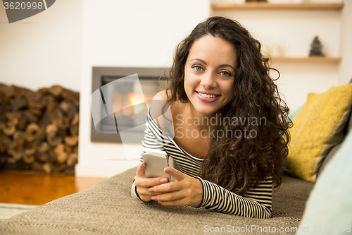 Image of Woman with her cellphone at home