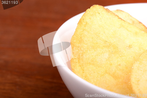 Image of Crispy potato chips close up on white plate 