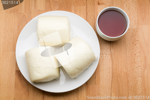 Image of Steamed bun hold with glass of tea