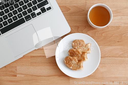 Image of Fish shapes waffle with tea and laptop