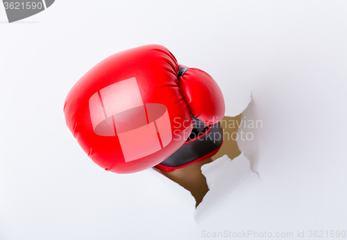 Image of Hand break through paper with boxing gloves