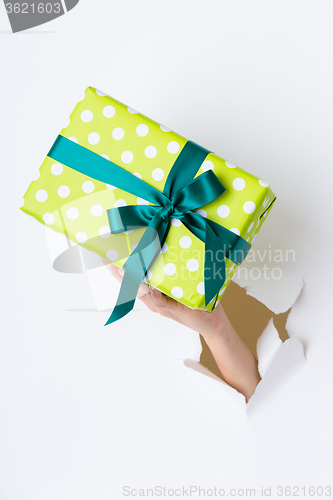 Image of Hand breaking white paper showing gift box