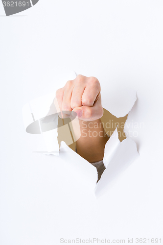 Image of Fist punching paper