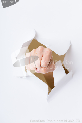 Image of Fist punching through paper