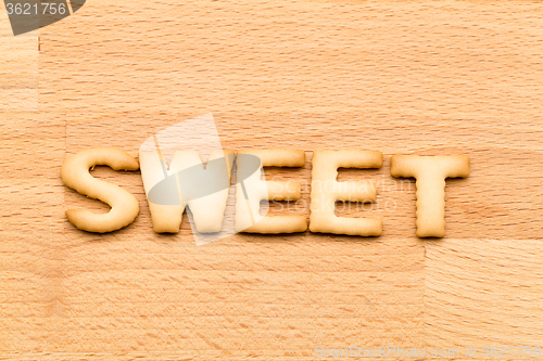 Image of Word sweet cookie over the wooden background