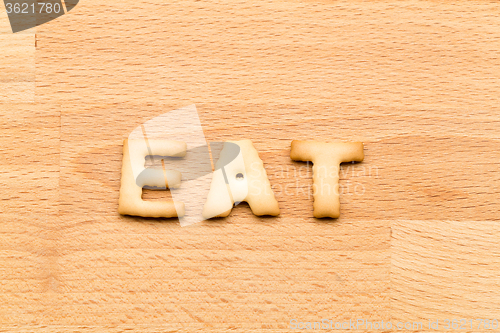 Image of Word eat cookie over the wooden background